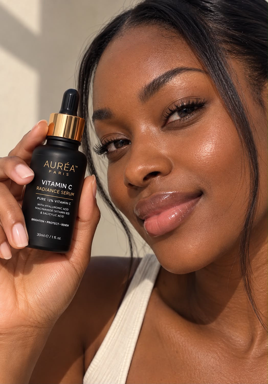 AURÉA Vitamin C Radiance Serum held by a model