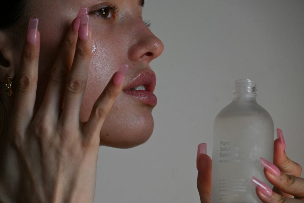 Woman with glowing skin and serum bottle